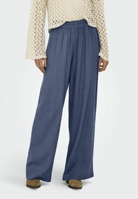 Pantalons larges en tissu bleu foncé uni, dotés d'une taille élastique et d'une texture légère et fluide.
