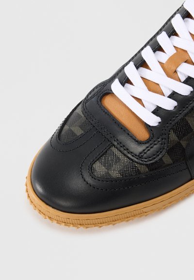 Schwarze Ledersneaker mit Obermaterial aus kariertem Textil, weißen Schnürsenkeln, beigen Akzenten und einer strukturierten Gummisohle. Runde Zehenform und klassisches Design.