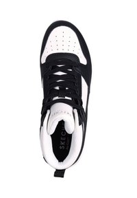 Czarno-biała sneaker z gładką skórzaną cholewką, okrągłym noskiem, perforowanymi detalami i sznurowanym zapięciem. Zawiera oznaczenie "Skechers" wewnątrz.