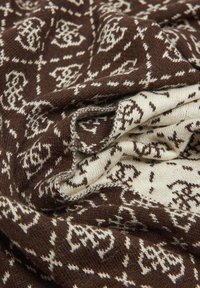 Sciarpa tessuta con motivo marrone e crema. Tessuto morbido, disegni intricati e accenti delicati creano un aspetto stratificato.