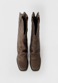 Brown leather ankle boots with a slouchy design, square toe, and deep cutouts at the collar. Smooth texture with minimal hardware accents.