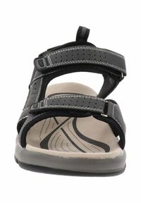 Sanda negra con dos correas ajustables y costuras en blanco contrastantes, plantilla acolchada en color beige y suela de goma texturizada.