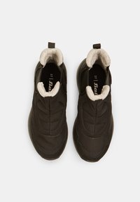 Fekete slip-on sportcipők steppelt anyagból készült felsőrészel és fehér műszőrme béléssel, kényelmes húzófüllel a saroknál.