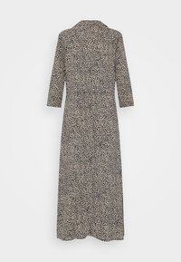 Robe longue à motifs floraux noirs et blancs, manches trois-quarts et encolure ronde, présentée sur un fond uni.