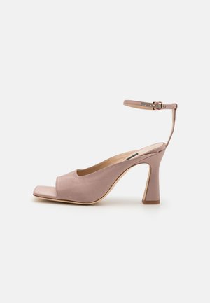 Rožinė audinio aukštakulnė bateliai su atvira pirštine, plona kulkšnies juostele ir plačiu bloku kulnu. Lygi tekstūra ir paprastas, elegantiškas dizainas.