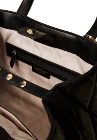 Borsa trapuntata nera con esterno in pelle liscia, dotata di interno in tessuto chiaro e scomparto con zip. Rifiniture in metallo dorato incluse.