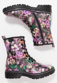 Bottines avec motif floral, dotées d'une surface texturée noir et gris, d'une fermeture éclair sur le côté et d'une semelle en caoutchouc noire avec un profil rugueux.