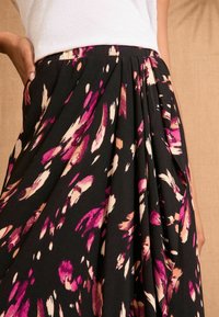 Melnā plisētā svārki ar purpura, rozā un krēma abstraktiem rakstiem; viegls audums; ar gludu jostu un kabatām.