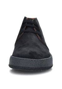 Scarpe in suede nero con punta arrotondata, dotate di lacci neri e una suola in gomma testurizzata. Accenti di cuciture arancioni ben visibili.