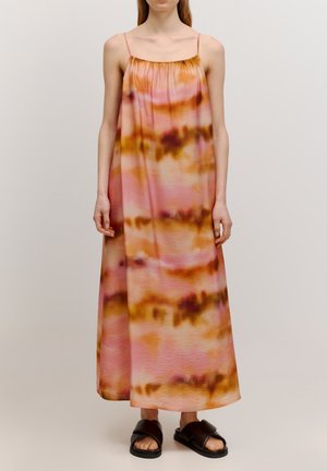 Maxi jurk in roze en oranje tie-dye patroon met dunne banden en een gerimpelde halslijn. Gecombineerd met zwarte slide sandalen.
