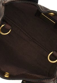 Interno di una borsa in pelle marrone con una superficie liscia, dotato di dettagli in metallo dorato, rivestimento in tessuto e due anelli di attacco circolari.