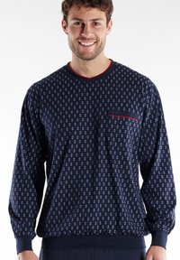 Navy long-sleeve pullover with all-over geometric pattern, V-neck, red accent on neckline, and small pocket on the chest. Soft fabric.