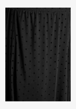 Tissu noir transparent avec des pois en velours surélevé et une ceinture élastique froncée sur une jupe ou une robe.