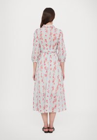 Obleka s cvetličnim vzorcem in vertikalnimi modrimi in belimi črtami, z vpasenim pasom, rokavi do tri četrtine in dolžino do sredine meč.