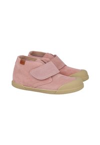 Un par de zapatos infantiles de ante rosa con suelas de goma beige y grandes correas de velcro sobre un fondo blanco.
