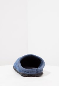 Blauwefelt pantoffel met een gestructureerde buitenkant, open achterkant en een zwarte rubberen zool. Zachte binnenvoering voor comfort.