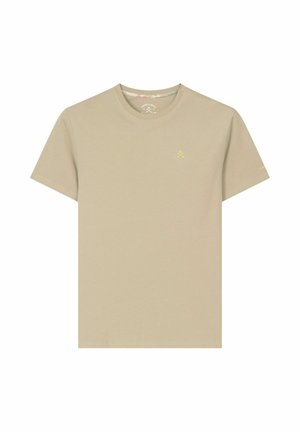 Camiseta beige de manga corta y cuello redondo con pequeño logo amarillo en el pecho izquierdo y texto sutil de la marca en la manga izquierda.