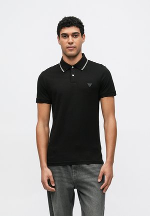 Polo nera a taglio slim, con colletto bianco a contrasto, chiusura con due bottoni e piccolo logo triangolare sul petto.