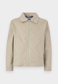 Beige, lightweight jacket featuring a collar, zip front, and side pockets. Made of smooth fabric, with a clean, minimalist design.