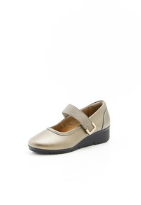 Zapato Mary Jane metálico dorado con una banda elástica, tacón bajo de cuña, superficie lisa y punta redondeada. Presenta un brillo sutil y suela negra.