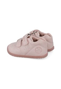 Zapatos infantiles de ante rosa con correas de Velcro, punta redondeada, acentos texturizados y suelas de goma con un logo en el lado exterior.