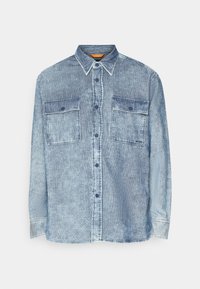 Chemise en velours côtelé bleu à manches longues avec fermeture boutonnée et deux poches poitrine, présentée sur fond blanc.