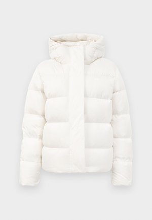 Giacca a vento bianca con colletto alto, dotata di chiusura con zip e ampi segmenti orizzontali. Realizzata in materiale leggero e trapuntato.