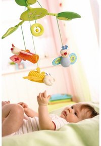 Colorful felt mobile with three plush toys: a butterfly, a bee, and a worm, hanging from green leaves, featuring bright patterns and textures.