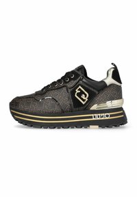 Baskets à motifs noirs et bruns avec accents dorés, semelle épaisse rayée, devant à lacets, logo sur le côté et détail métallique au talon.