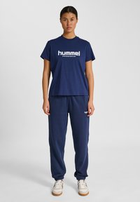 Navyblå bomullssportset som innehåller en t-shirt med rund hals och "hummel"-logotyp samt matchande sweatpants med elastiska muddar och logodetaljer.