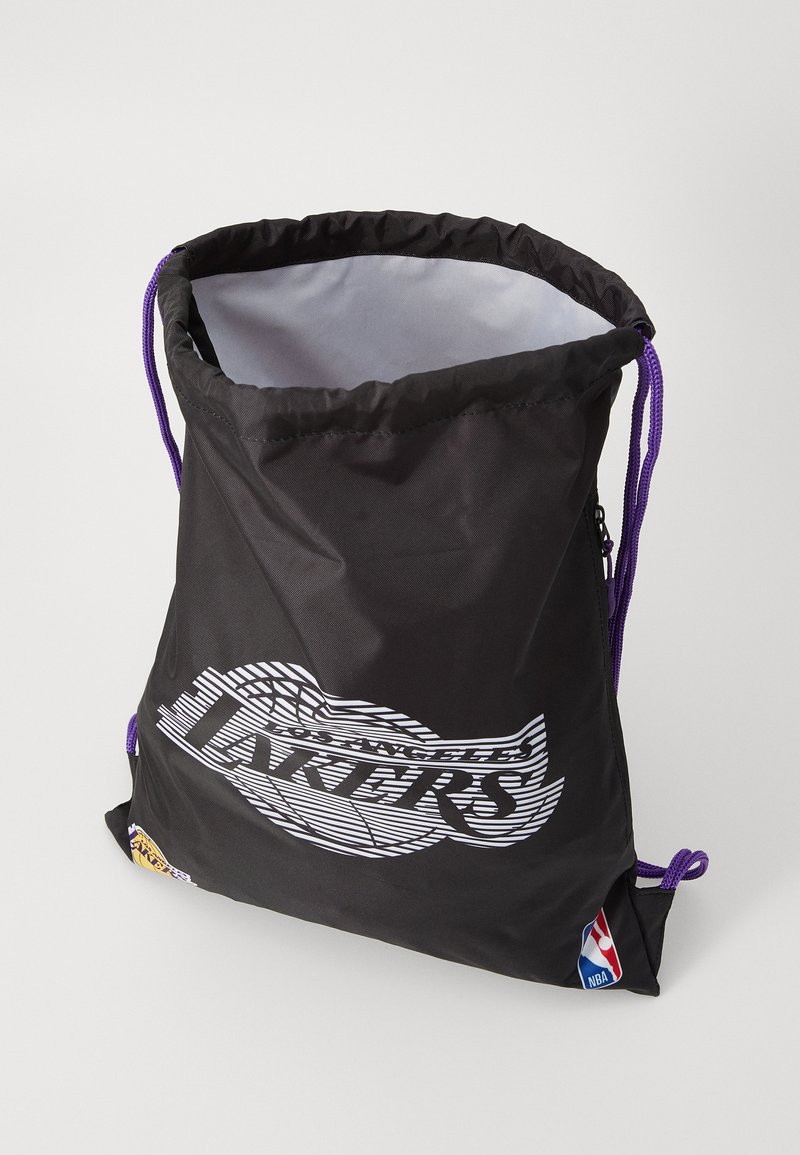 Bolsa de cordón negra hecha de nylon con una textura suave, que presenta el logotipo de "Los Angeles Lakers" en acentos blancos y morados, y un logotipo de la NBA en un lateral.