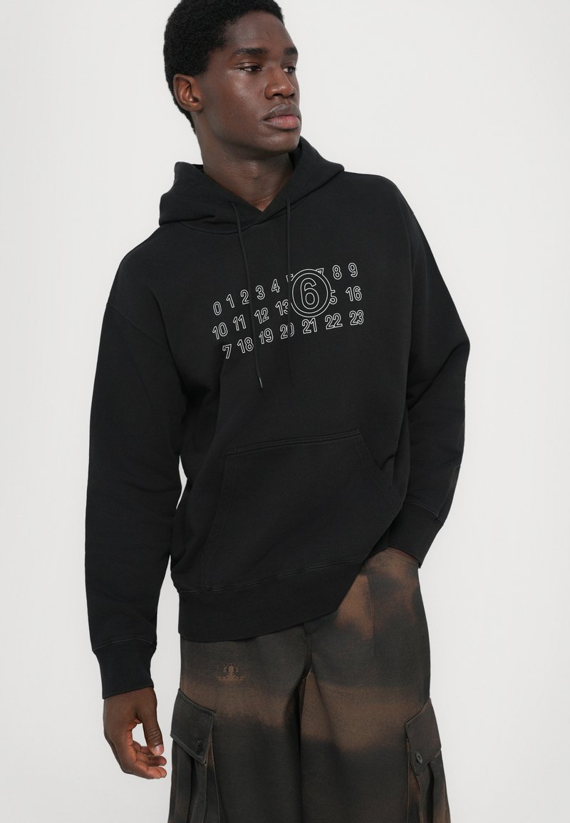 Felpa nera in cotone, con tasca a marsupio frontale e una grafica con numeri e un design circolare sul petto.