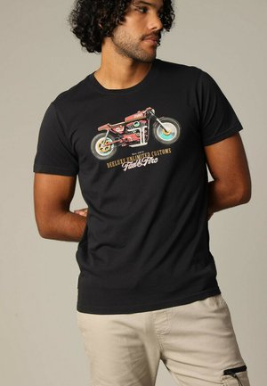 T-shirt en coton noir avec un graphisme de moto vintage aux accents colorés. Coupe décontractée, manches courtes et col rond.