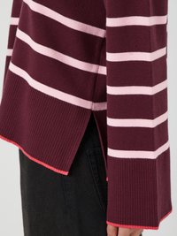 Maglione bordeaux con strisce rosa chiaro, polsini a coste e orlo spaccato. Il tessuto appare morbido e lavorato a maglia, con un accento rosa a contrasto sull'orlo.