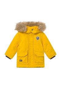 Veste matelassée jaune avec une capuche en fausse fourrure, deux poches avant, un écusson rond avec logo et des poignets en maille. Texture lisse et design chaud.