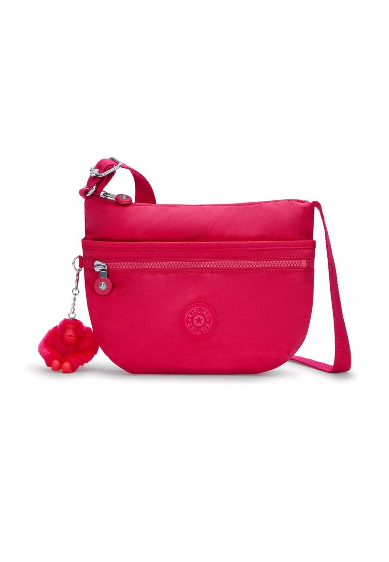 Borsa a tracolla di stoffa rosa con un compartimento con zip, logo circolare e un charm a forma di scimmia pelosa attaccato a un gancio in metallo.