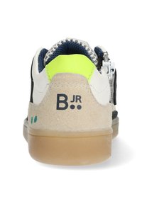 White and tan sneaker with a rubber sole, rear yellow accent, and blue suede detailing. Features a logo, lace-up closure, and suede texture.