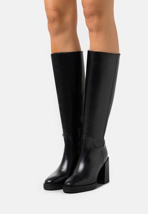 Zwarte leren kniehoge laarzen met een blokhak, voorzien van een gladde textuur en een zijrits voor gemakkelijk aantrekken.