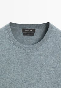 T-shirt en coton gris clair à col rond avec une étiquette de marque Massimo Dutti noire cousue à l'intérieur du col.