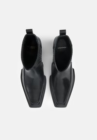 Μαύρες δερμάτινες ankle μπότες με λείο φινίρισμα, μυτερή μύτη, διακριτές ριμπέ λεπτομέρειες και κωδικάκια πίσω για εύκολη χρήση.