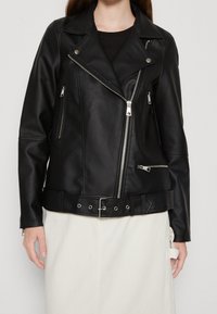 Czarna kurtka motocyklowa z ekoskóry z srebrnymi zamkami, zapięciem na napy i paskiem w talii. Wyposażona w liczne kieszenie na zamek.