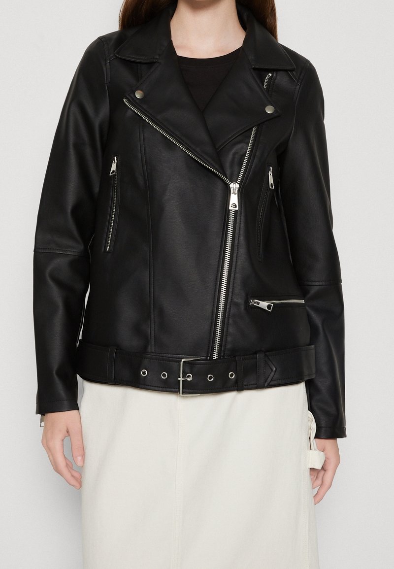Czarna kurtka motocyklowa z ekoskóry z srebrnymi zamkami, zapięciem na napy i paskiem w talii. Wyposażona w liczne kieszenie na zamek.
