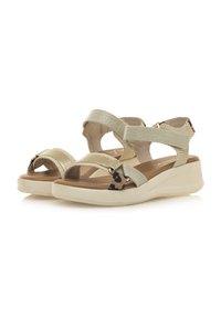 Sandalias de cuña beige con múltiples correas en materiales texturizados, que presentan un acento de estampado de leopardo y una plantilla acolchada.