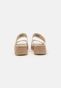 Béžové espadrilky na platformě s tkaným jutovým podešvem, elastickými popruhy a hladkým uzavřeným designem na zadní straně.