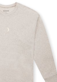 Sudadera color beige claro con mangas largas, hecha de una tela suave. Presenta un diseño sutil de luna y estrellas en estampado metálico en el pecho.