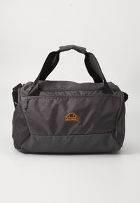 Sac de sport en tissu gris foncé avec une texture lisse, présentant un fond noir contrastant, des poignées supérieures et un logo orange sur le devant.