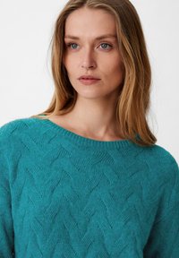 Türkiser Strickpullover mit einem strukturierten Zickzack-Muster, rundem Halsausschnitt und langen Ärmeln. Weiches, leichtes Material sorgt für zusätzlichen Komfort.