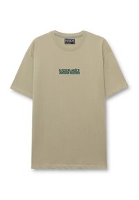Camiseta de algodón beige con mangas cortas, que presenta un texto bordado en verde "CIENCIA DE LA BOTÁNICA SUBACUÁTICA" en la parte delantera. Cuello redondo.