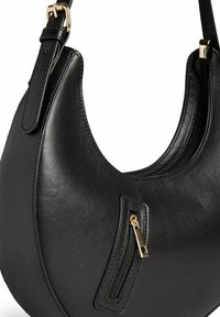 Bolso de mano de cuero negro con forma curva, que cuenta con un bolsillo con cremallera y acentos de hardware en dorado. Textura lisa y diseño minimalista.