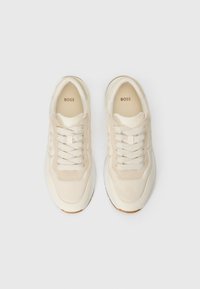 Beige sneakers med en glatt overdel av lær og semsket skinn, med hvite snører, rund tå og en teksturert gummisåle.